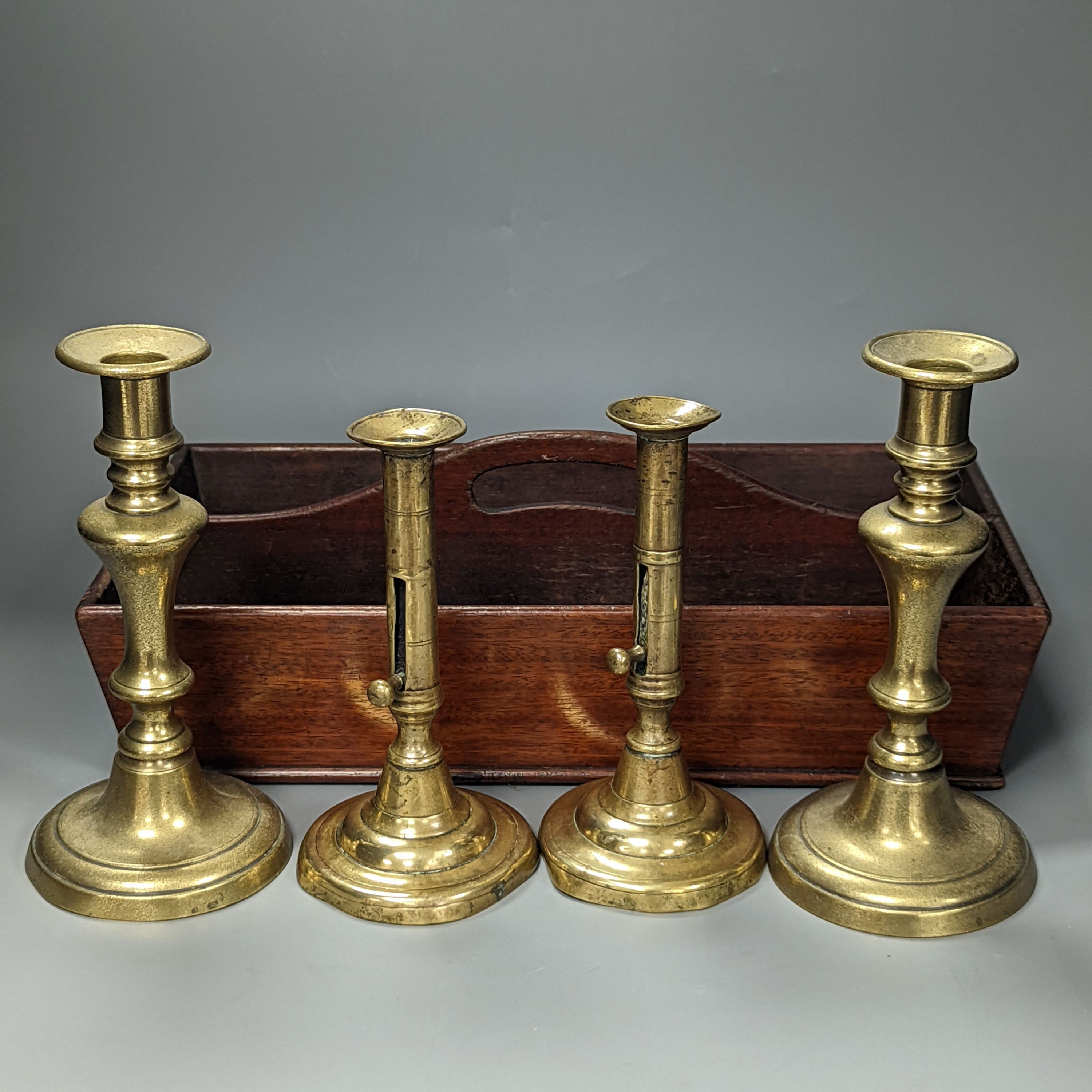 A pair of brass push-ejector candlesticks, a pair of Victorian brass candlesticks and a Victorian mahogany knife box, Knife box 38 cms wide.